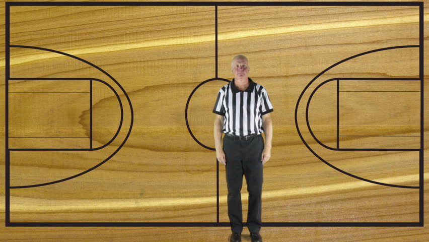 Man dressed in basketball referee uniform signaling the direction of play.