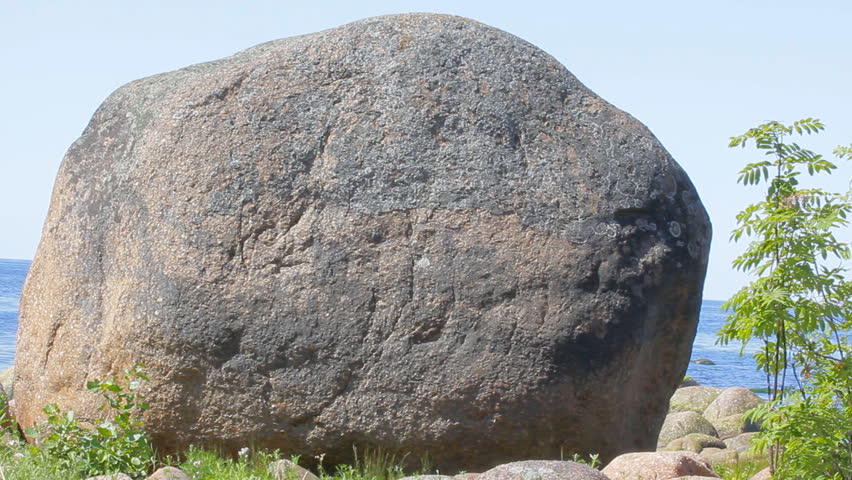 Huge erratic boulder on shore of Baltic sea as witness of ice age, after glacier movements. These rough scratches are at least 12,000 years old. Natural megalith. The cult of stones