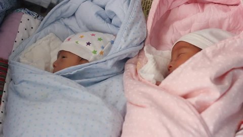 Boy and girl twins babies lying on the bed peacefully