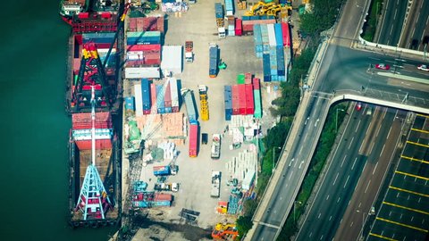 HONG KONG - JAN 23, 2015: Cargo ships loaded by crane with cargo containers at a busy port terminal. Hong Kong. Time lapse form aerial view point