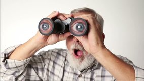 Senior adult male looking through binoculars with a surprised expression on his face.  - Powered by Shutterstock - Get 15% off with code: PIKWIZARD15