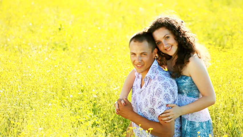 Love couple in the meadow. Look at camera
