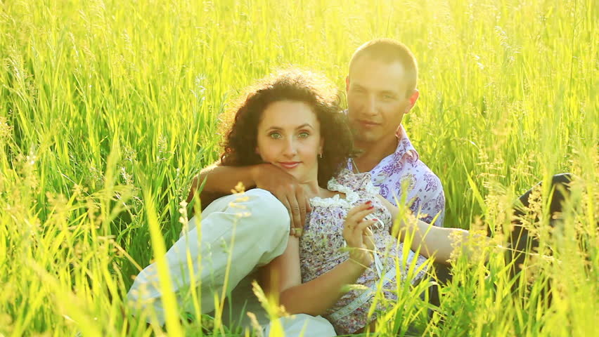 Love couple lies in the tall grass 