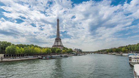 Low angle shot of Eiffel Tower with Seine River,France. Day Time Lapse with clouds dynamic.