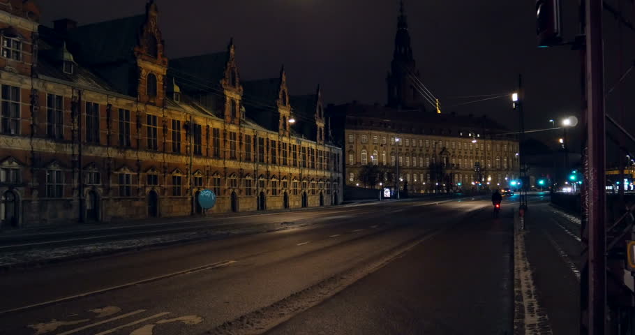 Night street view with cyclist and few cars in the historic part of Copenhagen, Denmark
