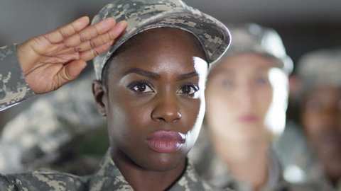 4K Close up on faces of mixed ethnicity female soldiers standing to attention and saluting. Shot on RED Epic.