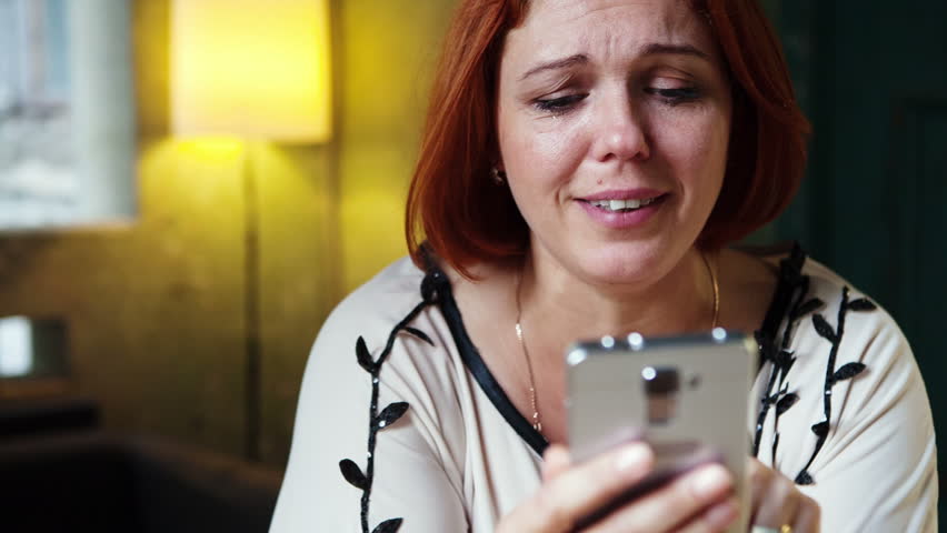 Tears of joy on the face of a woman who uses a smartphone. | Shutterstock HD Video #12044000