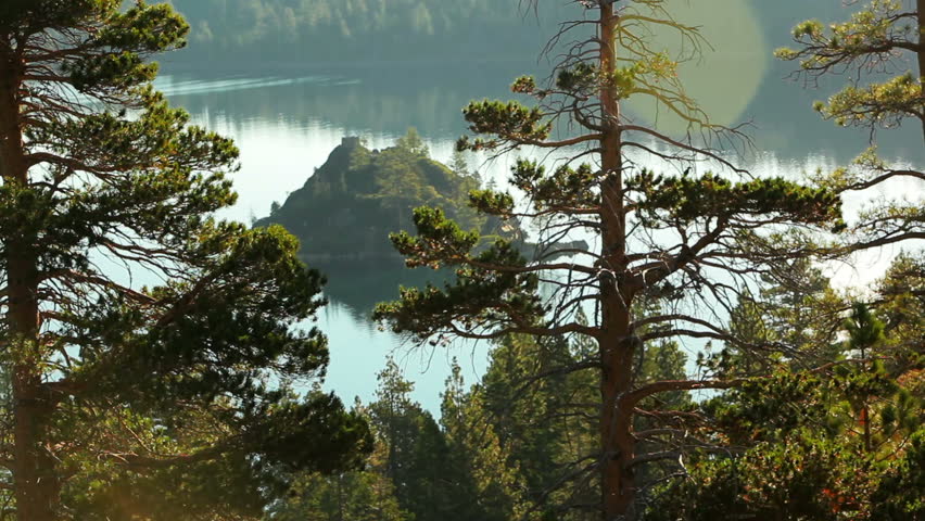 A static shot of Fannette Island (Tea House Island) in Emerald Bay, Lake Tahoe. The island is seen through tree branches on a hillside above. Emerald Bay State Park, Lake Tahoe, California.