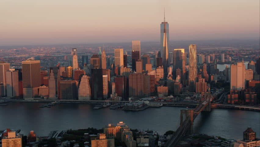 Aerial sunrise New York City skyline view of lower and Midtown Manhattan. Shot from helicopter with Freedom Tower, Empire State Building, Brooklyn Bridge and East River in shot.
