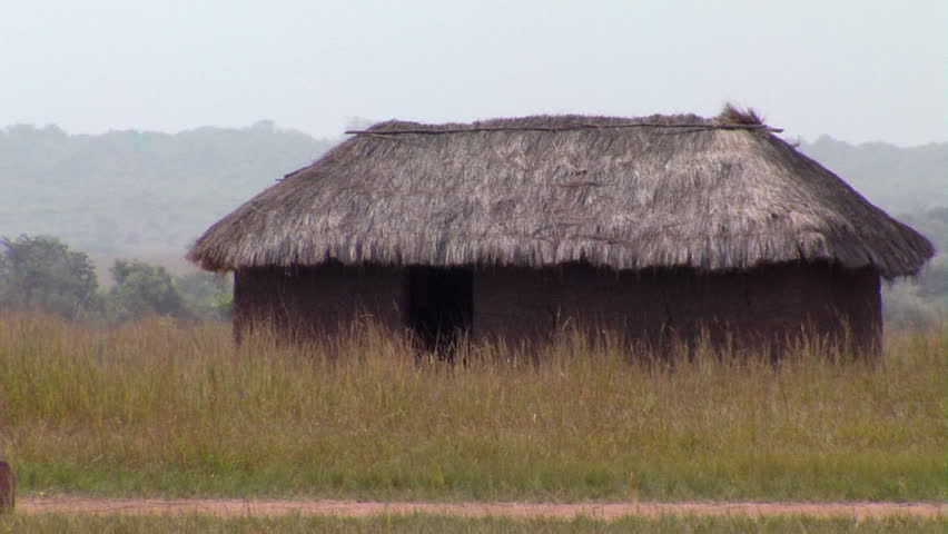 Kenya, Africa - October 2011: Wide shot of grass hut in field
