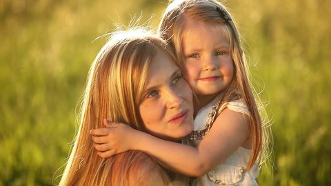 Little blonde girl hugging her mother 