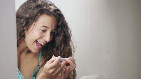 4K Young woman delighted to discover she is pregnant, in slow motion, shot on Red Epic Dragon