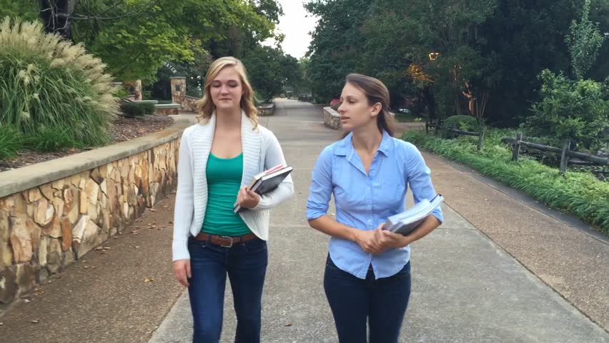 Attractive ladies walking on a college campus 