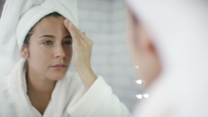 4K Close shot of woman applying moisturiser to her face in the mirror, shot on Red Epic Dragon | Shutterstock HD Video #12077078