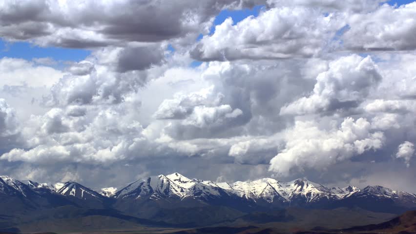 Large storm clouds over mountain range time lapse