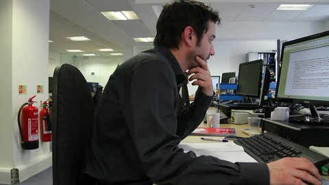 LONDON, UK, APRIL 2015 - Male Office Worker On Computer - Dolly Shot