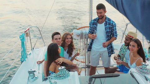 Young people is resting on the sailing yacht. Corporate party on a yacht. Friends spend a weekend on a yacht. Event on the yacht. Merry company is celebrating a birthday on a yacht.