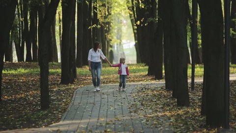 Family values: Mother and child walking in autumn park 