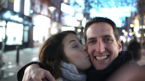 Fun couple in the city at night taking a selfie, as seen from the camera's p.o.v. Shot on RED Epic.