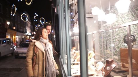 Attractive romantic couple shopping in the city at Christmas time. Shot on RED Epic.