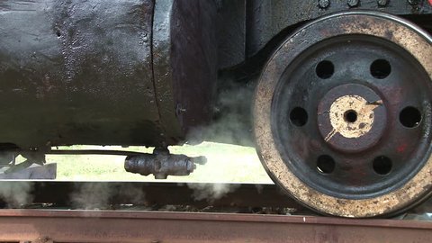 Steam locomotive detail as engine departs 