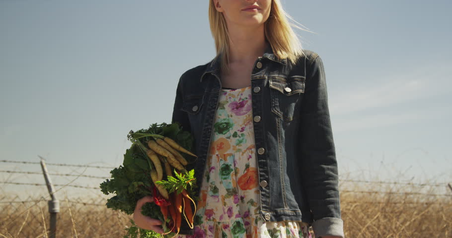 Young woman holding freshly picked vegetables