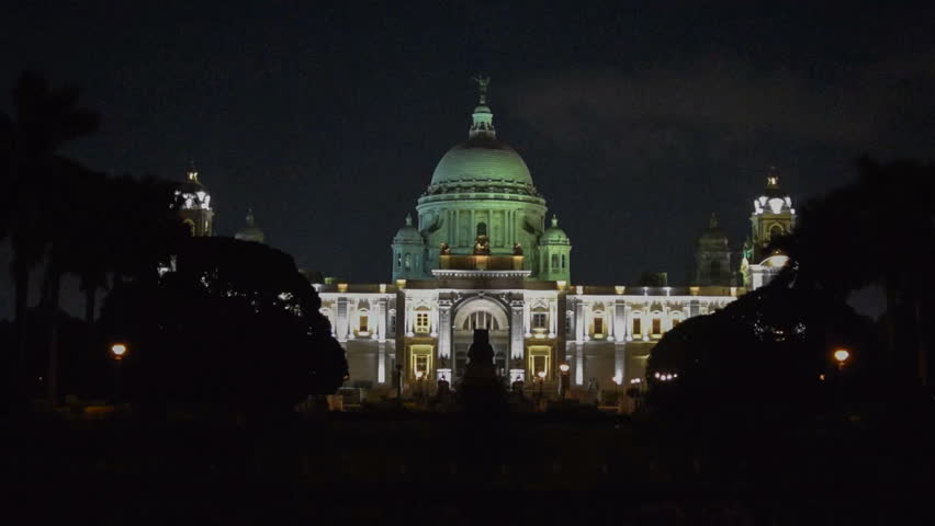 Beautiful landmark building of Kolkata, Victoria Memorial, illuminated with changing lights at night, time lapse stock video footage, Calcutta, West Bengal, India