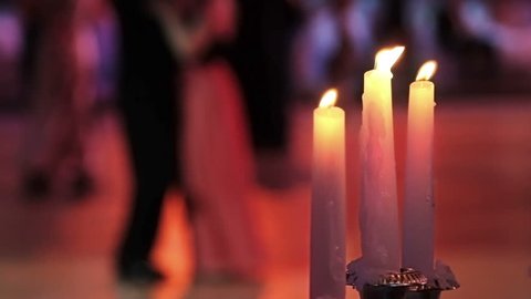 Dancing couples, burning candle and beautiful flowers. Traditional Vienna ball.