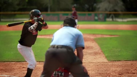 Really cool slow motion of a baseball player batting during a game and running towards first base.  All of the people including pitcher and catcher are unrecognizable.