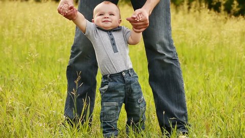 Baby boy learns to walk with father. : stockvideo