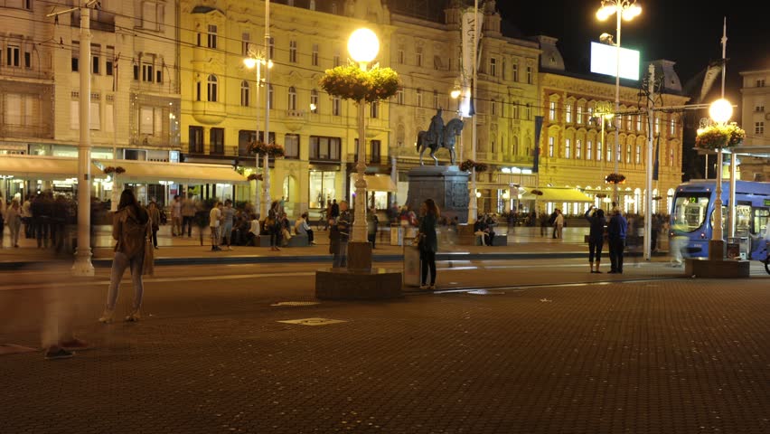 The Main square in Zagreb, Croatia by night. People passing by, time lapse. Tram station in background. Autumn 2014.
