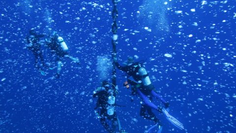 Divers on 5 min stop after Zenobia wreck dive, with hundreds bubbles around