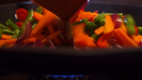 Frying and mixing vegetables close up video