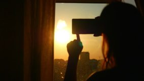 Young Girl Taking Photos Of City With blurred architectures on Mobile Smart Phone at home window in slow motion - Powered by Shutterstock - Get 15% off with code: PIKWIZARD15