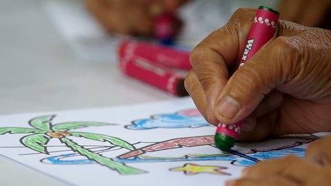 Chiang Mai, Thailand - OCROBER 9, 2015:  hand movement of adult person is painting the picture with crayon in AUGUST, 2015 in Chiang Mai, Thailand