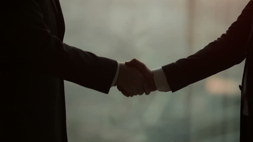Silhouette of two businessmen talking and shaking hands, standing by the window at sunset, for the construction of a skyscraper and crane in the background, close-up | Shutterstock HD Video #12178607