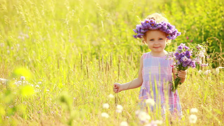 Child with violet flowers in the park 