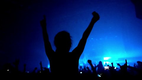 Fans waving their hands and hold the phone with digital displays the crowd at a rock concert.Here is  footage of people crowd partying at a concert or a night club. 