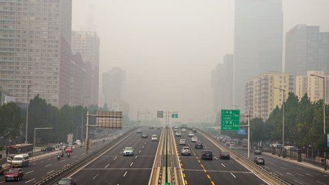 China's capital city of Beijing street traffic of automobiles. Foggy day, smog, air pollution.