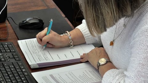 Woman sitting at a desk filling out a form.