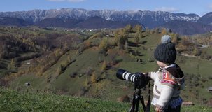 Little boy photographs the nature, autumn mountain landscape