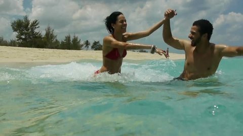 Just married young people, man and woman playing and running into the water on a tropical beach in Cuba, sea, holidays, vacation: stockvideo