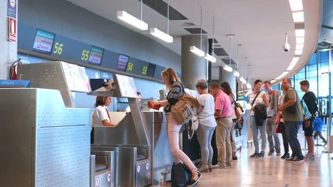 VALENCIA, SPAIN - OCTOBER 11, 2015: Airline passengers checking in at an airline counter in the Valencia Airport. About 4.98 million passengers passed through the Valencia Airport in 2014.