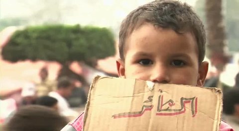 CAIRO - CIRCA JAN 2011: Child with protesting label, Tahrir Square, circa January 2011, Cairo, Egypt. Tahrir Square was the focal point of the 2011 Egyptian Revolution where demonstrations grew to 250,000 plus people by day 6, January 31, 2011. 