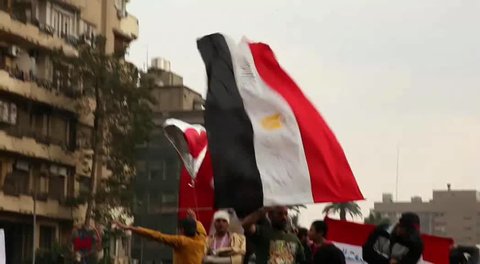 CAIRO - CIRCA JAN 2011: Man waves Egyptian flag, Tahrir Square, circa January 2011, Cairo, Egypt. Tahrir Square was the focal point of the 2011 Egyptian Revolution where demonstrations grew to 250,000 plus people by day 6, January 31, 2011.
