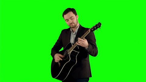 Young man playing guitar on a Green Screen, Chroma Key. Professional shot on BMCC RAW with high dynamic range. You can use it e.g in your commercial video, business video, office theme.