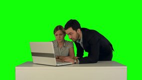 Couple discussing new project on the laptop. Teamwork concepts. on a Green Screen, Chroma Key. Professional shot on BMCC RAW with high dynamic range. You can use it e.g in your commercial video