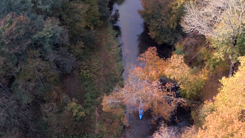 Man kayaking on the forest river. 
HD aerial shot. 