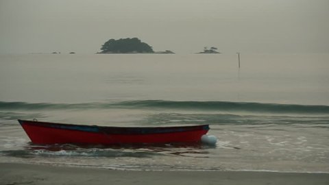 4k resolution of haze in early morning at beach with boat and water splash at sea shore