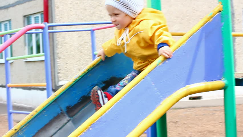 cute little girl in yellow on slide - slow motion